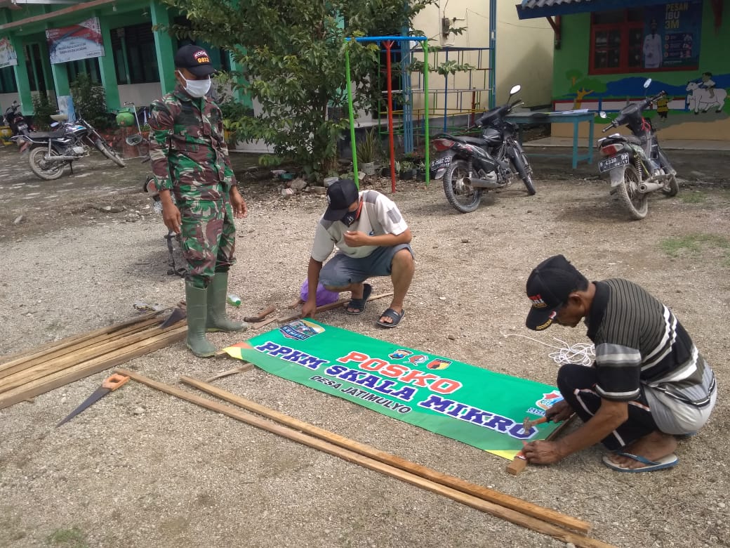 Anggota Satgas TMMD 110 Bojonegoro Membantu Warga Menata Banner