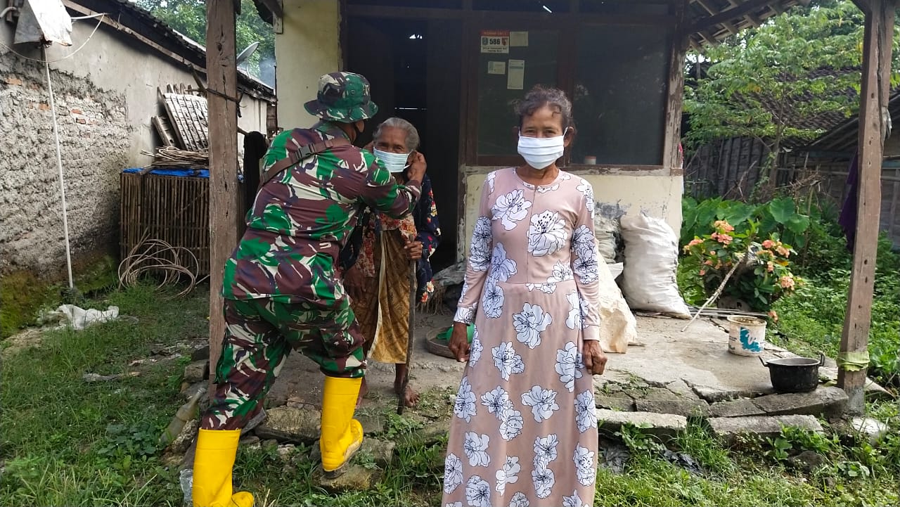 Sertu Edi, Pasangkan Masker Untuk Warga Dilokasi TMMD 110 Bojonegoro