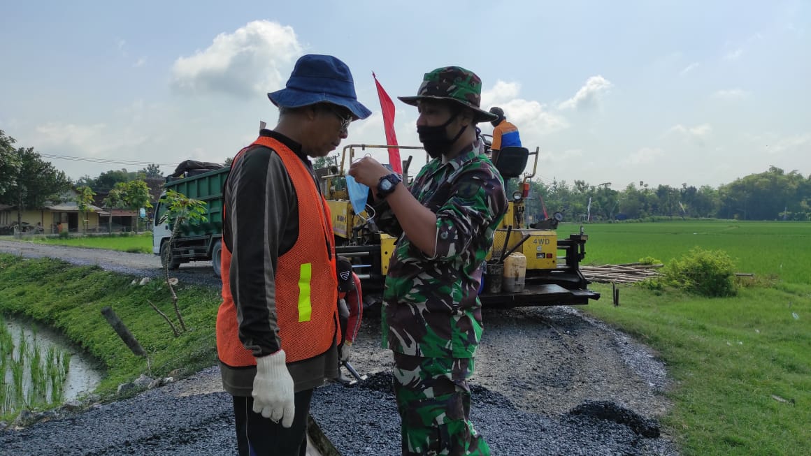 Cegah Corona Dilokasi TMMD Bojonegoro, Proses Pengaspalan Satgas Juga Bagikan Masker