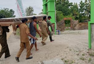 Bareng Warga, Satgas TMMD Kodim Bojonegoro Pikul Meja Kayu Besar