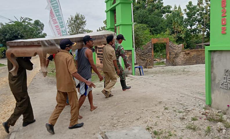 Bareng Warga, Satgas TMMD Kodim Bojonegoro Pikul Meja Kayu Besar