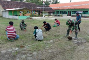 Satgas TMMD Kodim Bojonegoro Ajak Anak SD Rapikan Lapangan Sekolah