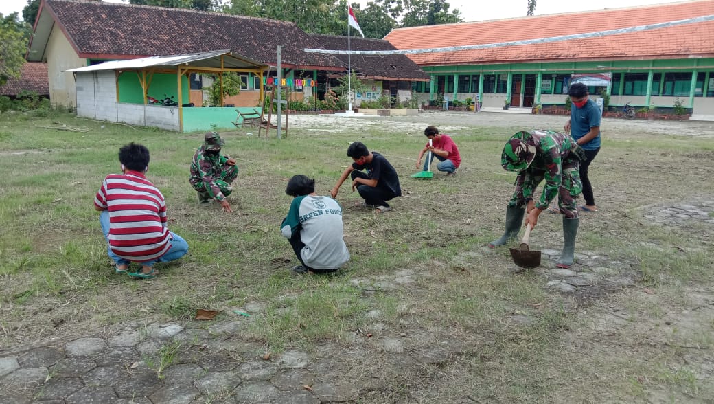 Satgas TMMD Kodim Bojonegoro Ajak Anak SD Rapikan Lapangan Sekolah