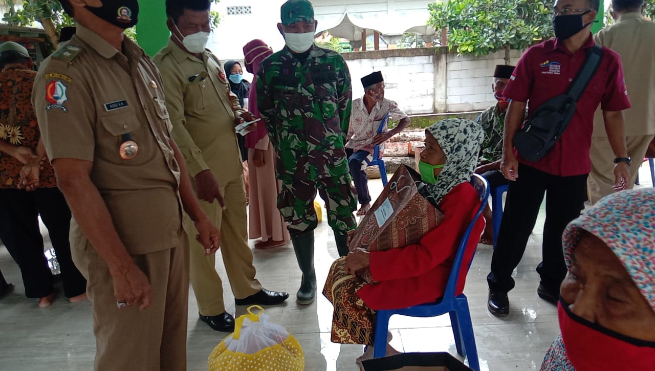 Anggota Satuan Tugas TMMD Kodim Bojonegoro Mendampingi Pemberian Bantuan Sosial