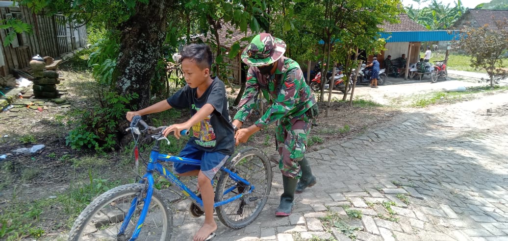 Satgas TMMD 110 Bojonegoro Bantu Anak-Anak Dusun Kramanan Belajar Sepeda