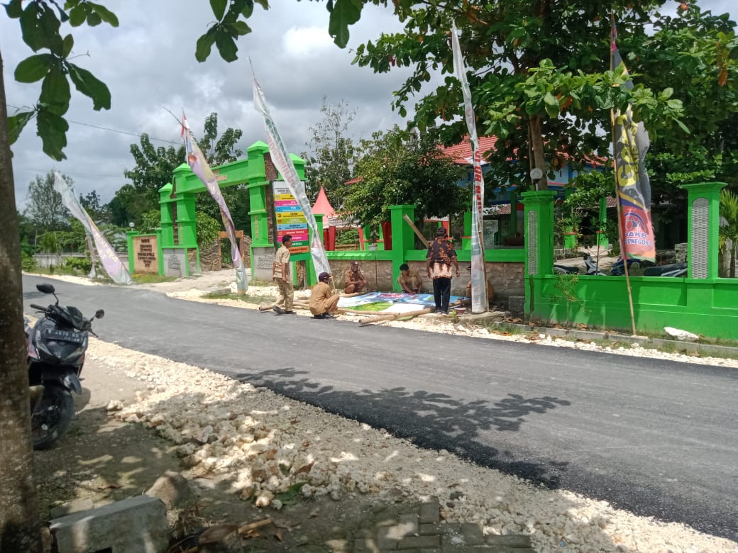 Kampanyekan Prokes, Satgas TMMD Bojonegoro Bantu Perangkat Desa Pasang Banner Imbauan Cegah Covid-19