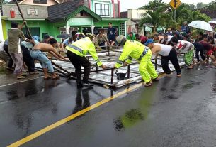 Petugas Gabungan Dibantu Warga Evakuasi Baliho Tumbang di Jalinbar Pugung