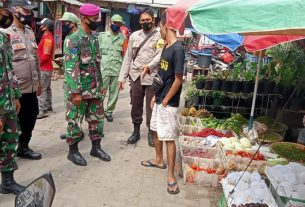 Babinsa Koramil 410-01/Panjang Kodim 0410/KBL Serda Ismanto berikan himbauan kepada pengunjung pasar tradisional