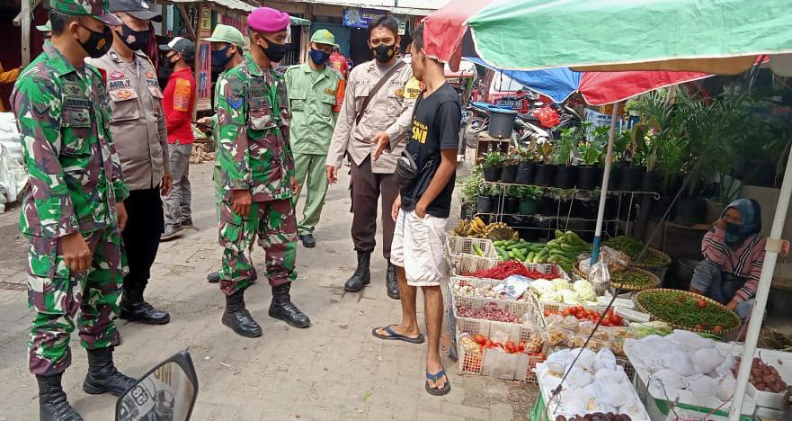 Babinsa Koramil 410-01/Panjang Kodim 0410/KBL Serda Ismanto berikan himbauan kepada pengunjung pasar tradisional