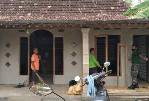 Anggota TNI Satuan Tugas TMMD Bantu Pasang Kusen Di Rumah Santoso