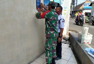 Bersama Security Babinsa Nusukan Pasang Pamflet Pedoman Penanganan Covid 19 di Pasar Tradisional