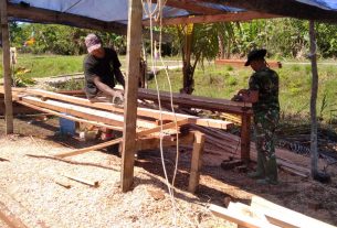 Danramil 1712-02/Pantai Timur Bantu Warga Potong Kayu dan Bersihkan Halaman Gereja