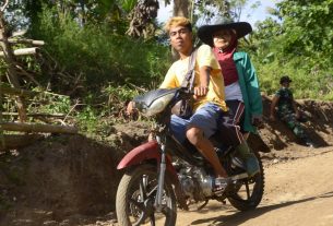 Masyarakat Tersenyum Sambil Melintasi Lokasi TMMD ke -111 kodim 1407/Bone