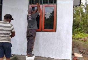 Anggota Satgas TMMD Bersihkan Sisa Semen di Bangunan Gereja