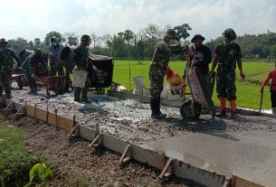 Anggota Satgas TMMD Kebut Pekerjaan Rabat Beton Jalan, Terlihat Saat Menuangkan Adonan Cor