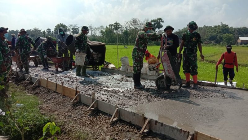 Anggota Satgas TMMD Kebut Pekerjaan Rabat Beton Jalan, Terlihat Saat Menuangkan Adonan Cor