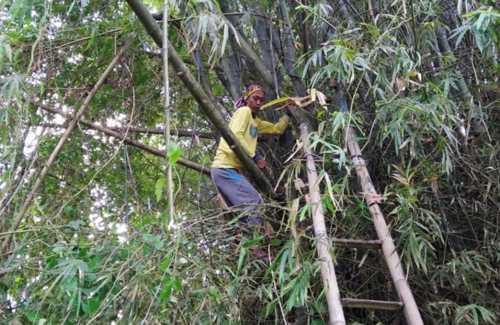 Darsono Memotong Bambu Untuk Mendukung Acara Penutup TMMD