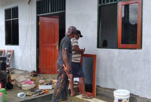 Dibantu Warga, Satgas TMMD Pasang Jendela di Balai Kampung