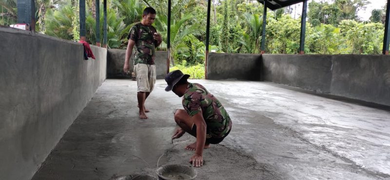 Pengacian Lantai Balai Kampung TMMD Dilakukan dengan Gotong-royong