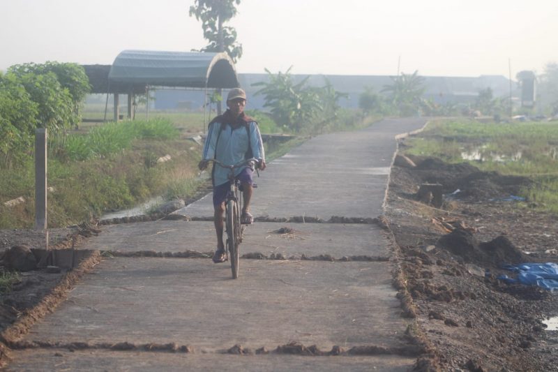 Sangat Menikmati Perjalanan, Terlihat Satu Warga Melintas Di Jalan Yang Baru Dibangun