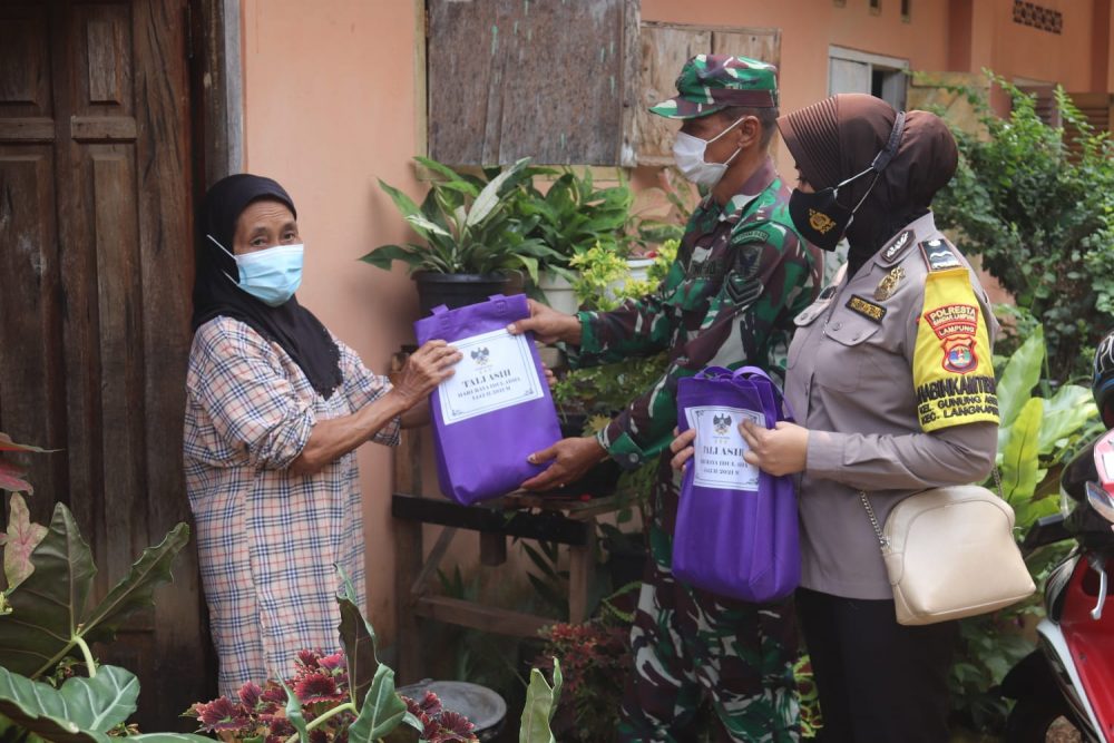 Sertu Suwarto membagikan daging qurban kepada warga