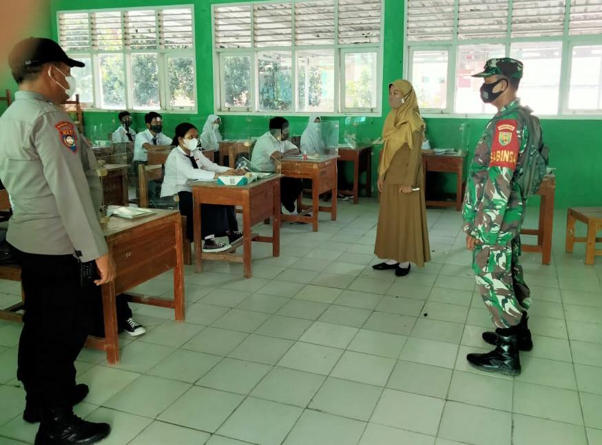 Sertu Riyatno bersama Bhabinkamtibmas memantau kegiatan Pembelajaran Tatap Muka