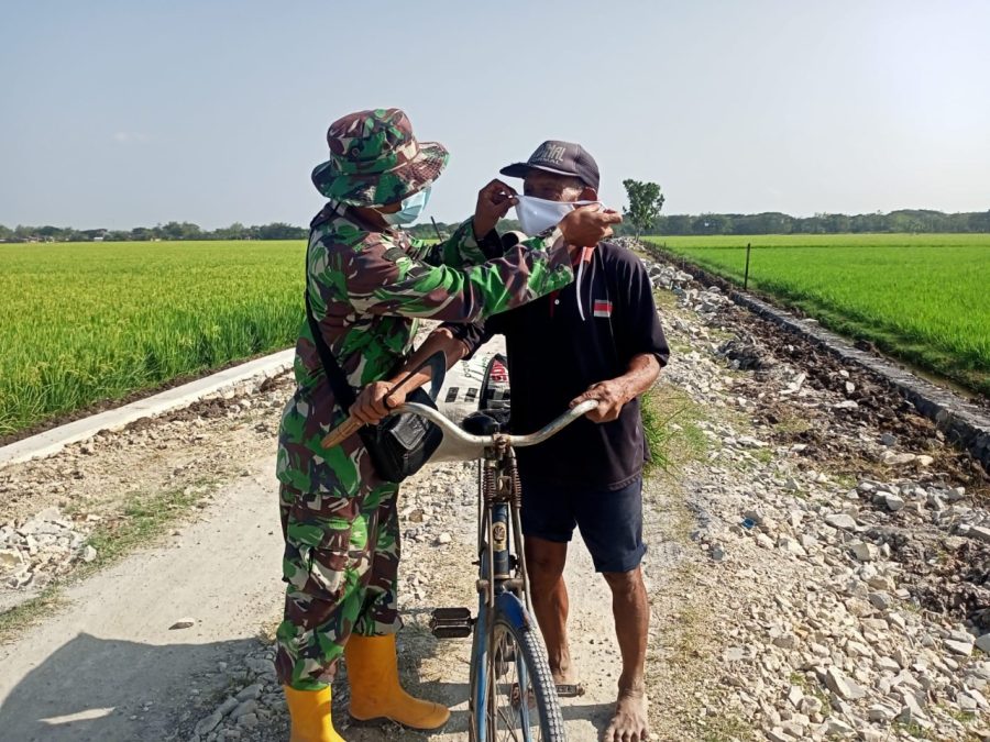 Babinsa Majasto, Intensif pantau perkembangan sasaran Fisik TMMD sekaligus ingatkan warga tentang Prokes dengan membagikan Masker