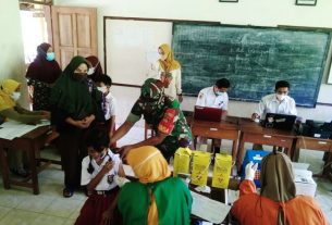 Kepedulian Babinsa Kepada Siswa SD Saat Menerima Vaksinasi