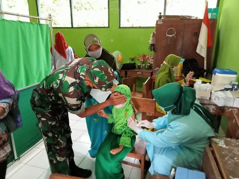 Dampingi Vaksinasi, Babinsa Beri Semangat Anak-Anak Agar Tak Takut Disuntik