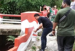 Anggota Koramil 410-02 TBS Hiasi Jembatan Sungai Kampung Pancasila Dengan Warna Merah Putih
