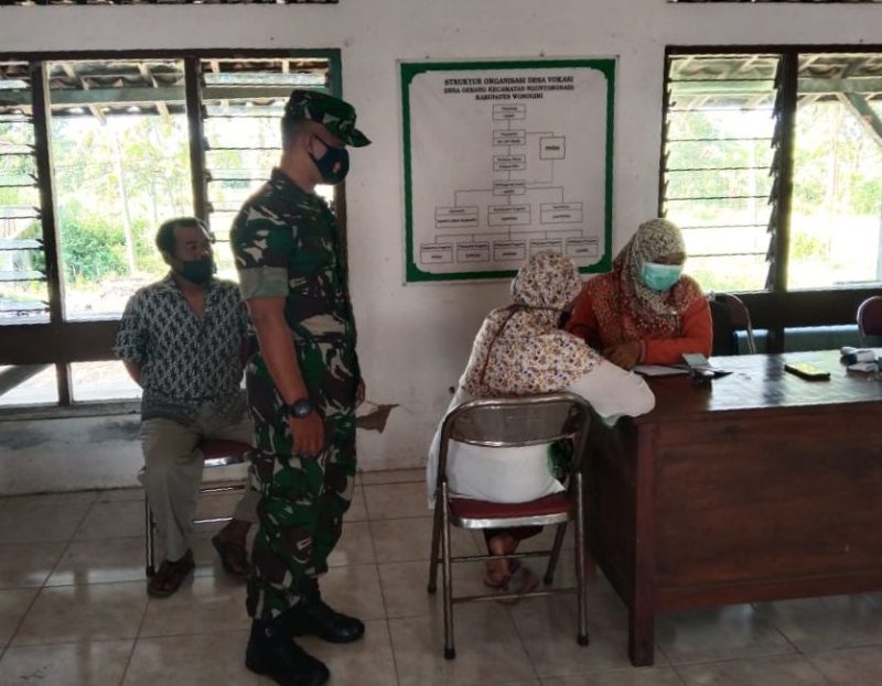 Guna Kelancaran Pelaksanaan Vaksinasi, Anggota Koramil Membantu Tenaga Kesehatan Berikan Pengamanan