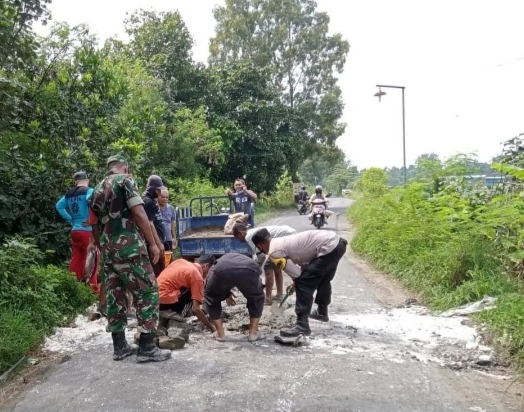 Babinsa Sawit Dan Warga Gotong Royong Tutup Jalan Berlubang