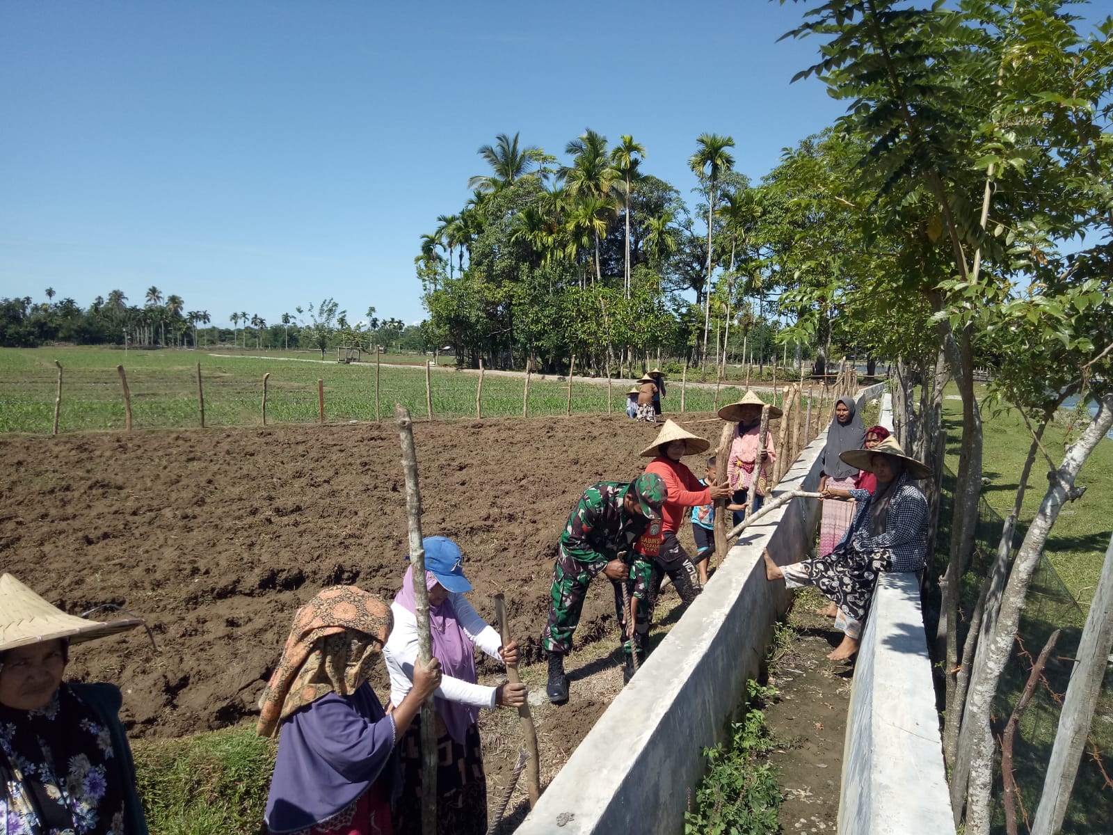 Babinsa Posramil 05/PC Bantu Warga Pasang Pancang Pagar Untuk Lindungi Tanaman Dari Hama