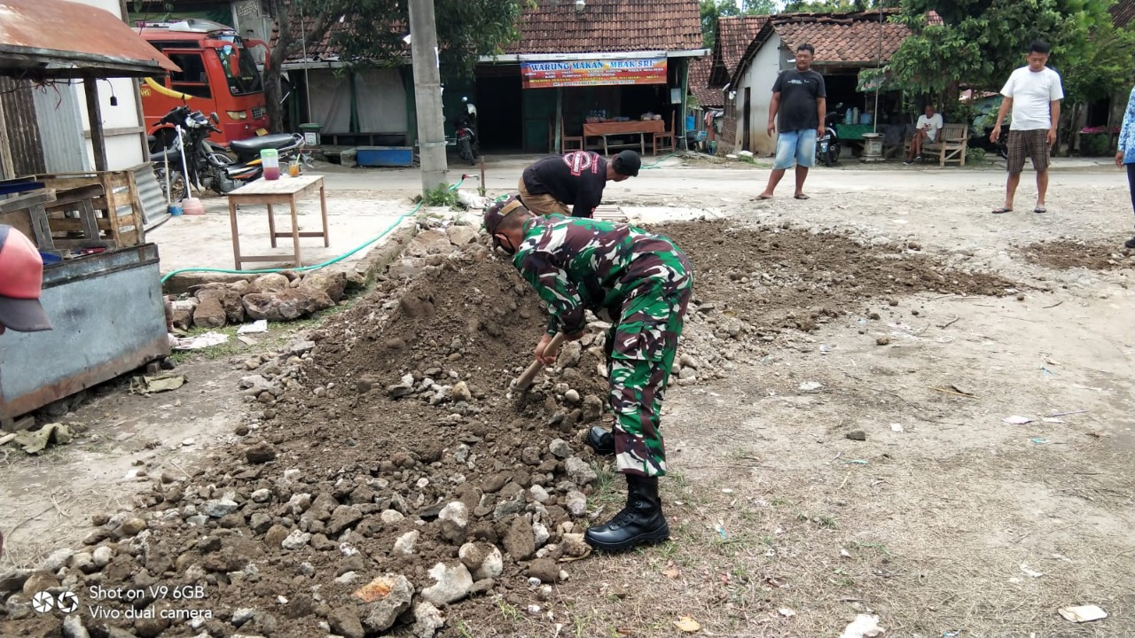 Berikan Rasa Aman Pengguna Jalan, Babinsa Bantu Warga Tambal Jalan Berlubang