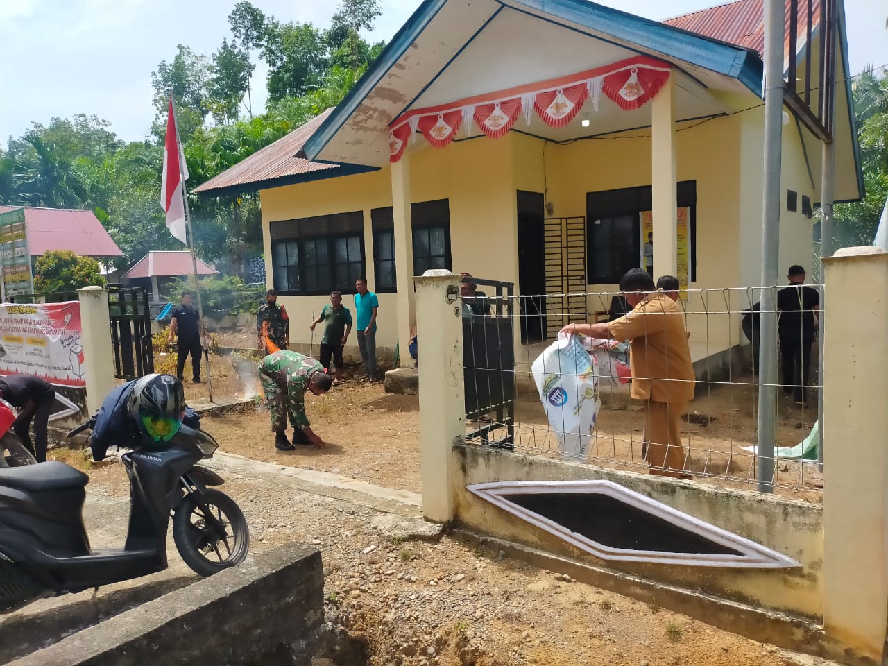 Babinsa Koramil 10/Woyla Barat Ajak Perangkat Desa Alue Keumuning Bersihkan Kantor Keuchik Agar Lebih Asri Dan Rapi
