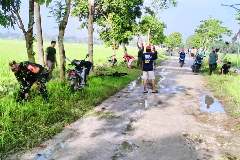 Bersama Pemdes dan Warga Sumuragung, Babinsa Sumberrejo Bojonegoro bersihkan Jalan Poros Desa