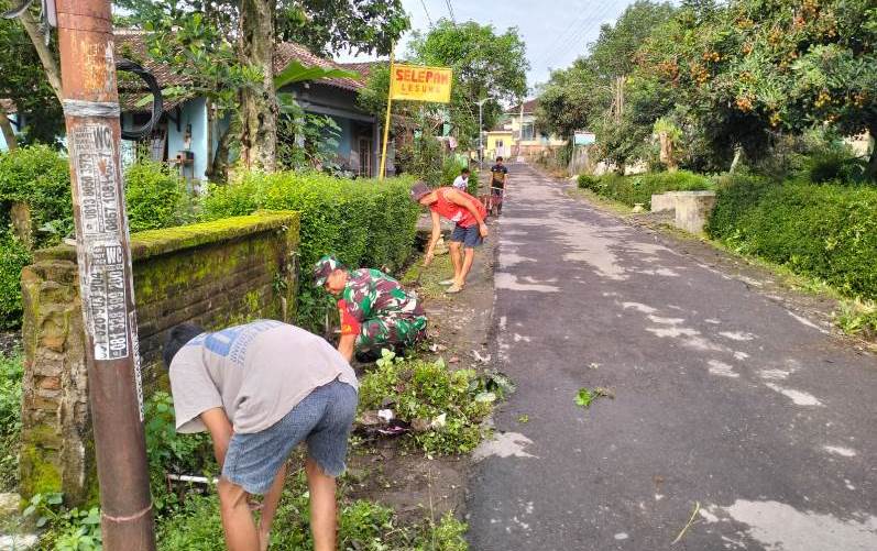 Babinsa Gotong Royong Bersihkan Jalan Lingkungan Binaan