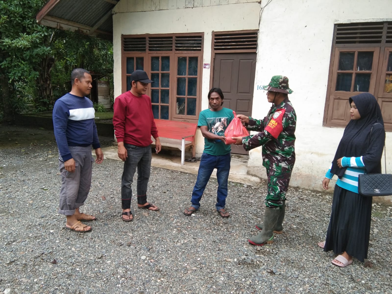 Main lumpur lagi Babinsa Koramil 10/Woyla Barat membersihkan dalam rumah pasca bencana Banjir