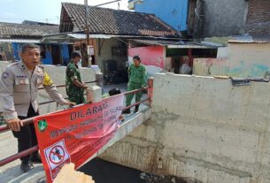 Peduli Lingkungan, Babinsa Kelurahan Jagalan Bersama Bhabinkamtibmas Pasang Spanduk Larangan Buang Sampah di Sungai Mbah Sonto