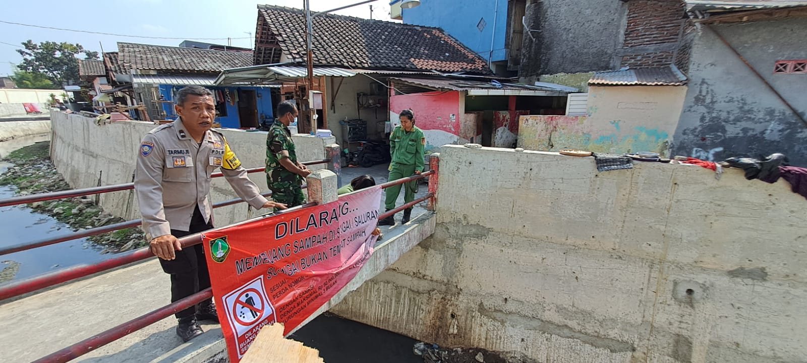 Peduli Lingkungan, Babinsa Kelurahan Jagalan Bersama Bhabinkamtibmas Pasang Spanduk Larangan Buang Sampah di Sungai Mbah Sonto