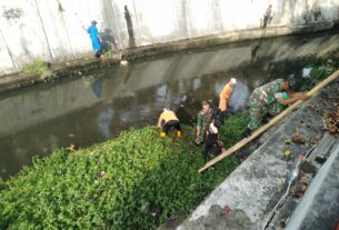 Tanpa Ragu, Babinsa Kestalan Terjun Ke Sungai Bantu Pembersihan Saluran Air