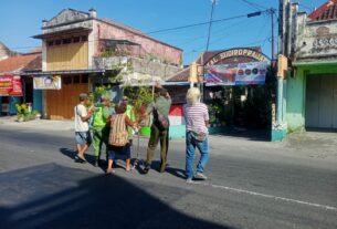 Bentuk Kepedulian, Babinsa Sudiroprajan Bantu Warga Dalam Menyebrang Jalan