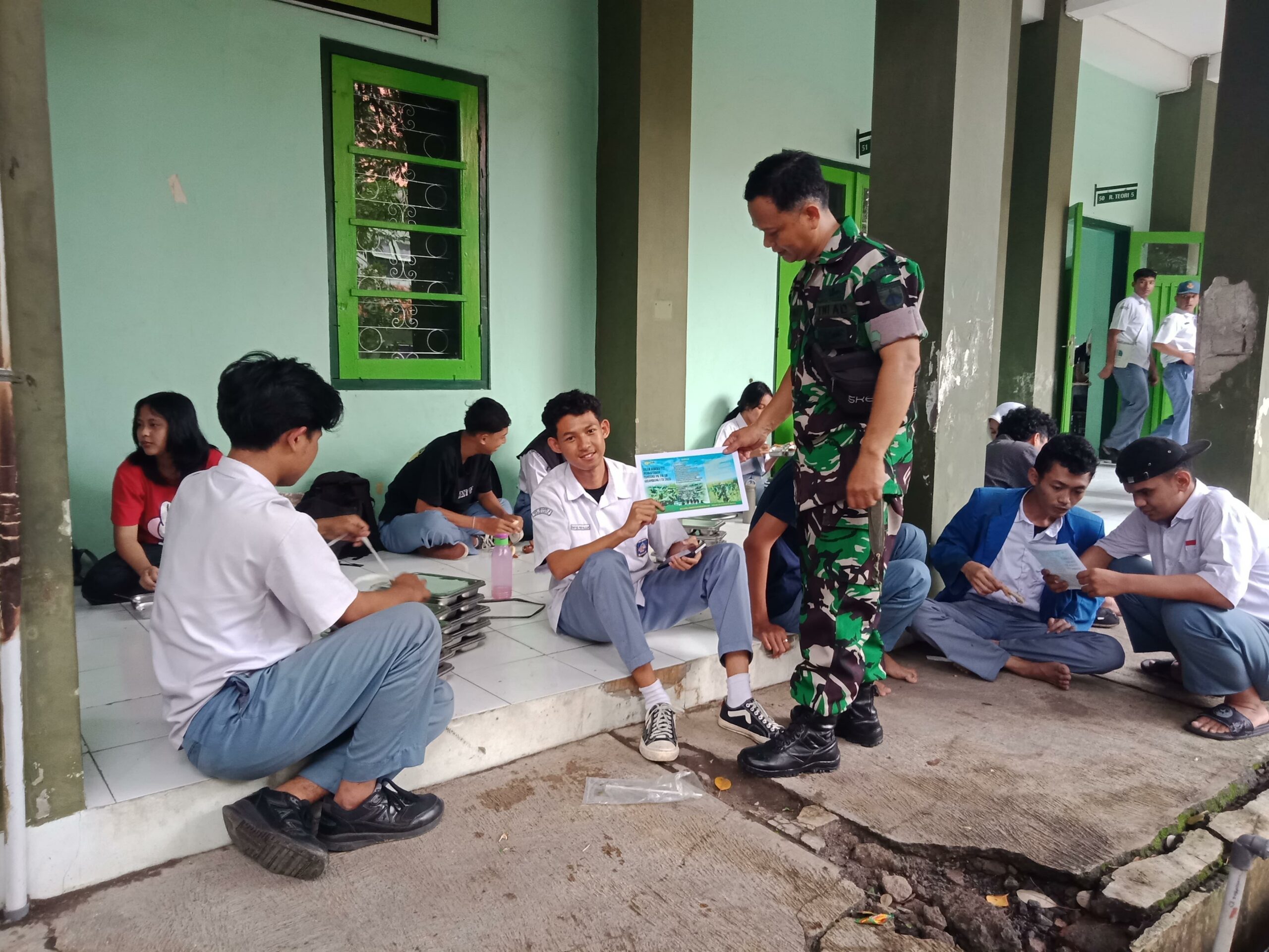 Disela-sela Waktu Bantu Pendistribusian MBG, Babinsa Kepatihan Wetan Sosialisasikan Rekrutmen Pendaftaran TNI AD Bagi Siswa-Siswi SMKN 08/Surakarta